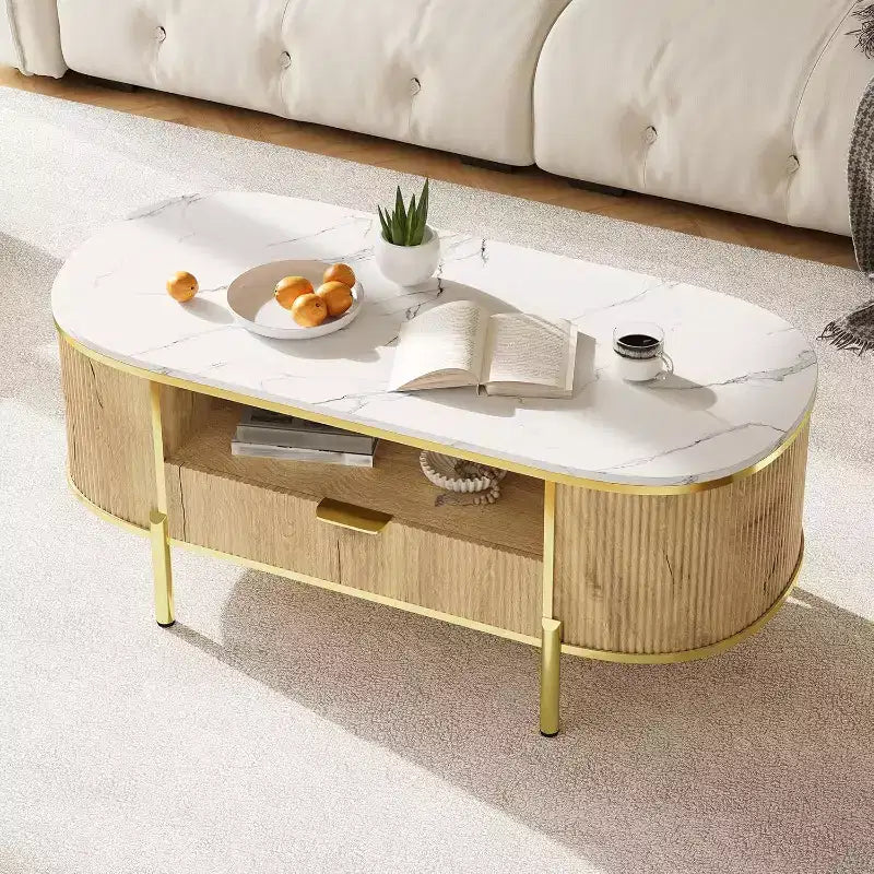 Tavolino da caffè scanalato moderno con cassetto, piano ovale in finto marmo da 122 cm e gambe dorate per soggiorno
